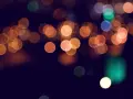 Rozmyte, okrągłe światła tworzą magiczny **bokeh** na ciemnym tle.