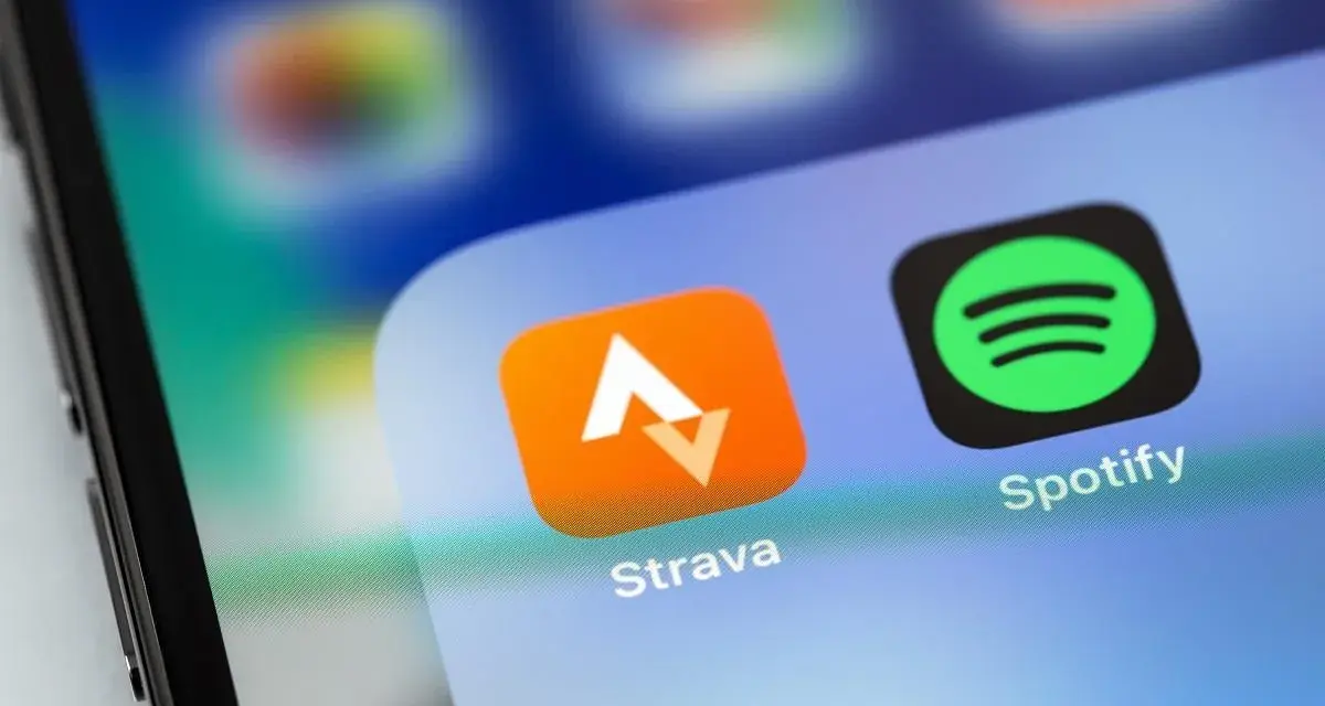 Ikona aplikacji Strava, idealna do śledzenia tras rowerowych, obok Spotify na ekranie smartfona.