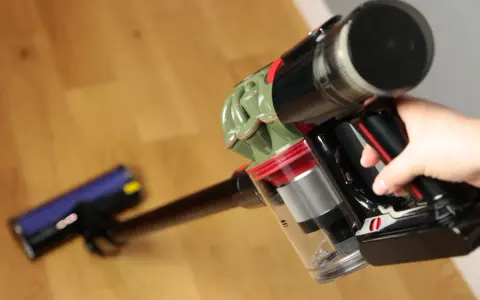 Ręka trzyma odkurzacz Dyson V8. Czy warto? Zobacz, jak łatwo sprząta podłogę.