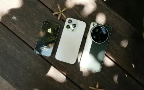 Trzy telefony na drewnianym stole: stary iPhone, biały iPhone i zielony telefon z najlepszym aparatem Leica.