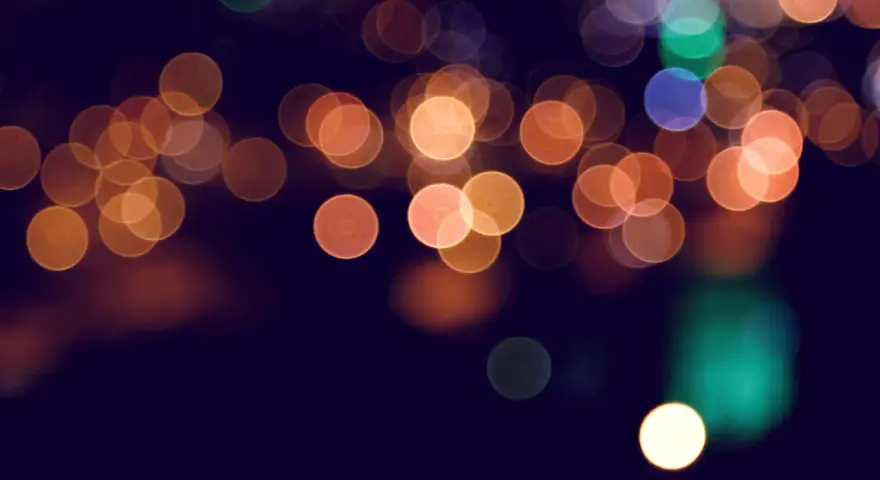 Rozmyte, okrągłe światła tworzą magiczny **bokeh** na ciemnym tle.