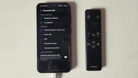 Telefon podłączony do telewizora przez USB. Ustawienia USB na ekranie telefonu pokazują opcje przesyłania plików, co jest kluczowe, jak połączyć telefon z telewizorem.