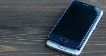 Dwa telefony leżące na drewnianym blacie. Dowiedz się, jak zlokalizować telefon, gdy zgubisz go lub zostanie skradziony.